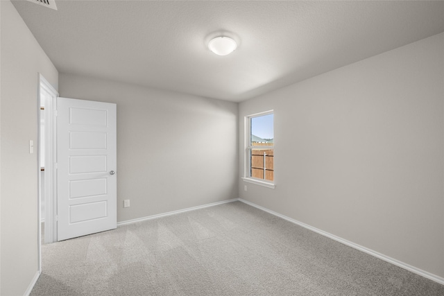 unfurnished room with baseboards and carpet flooring