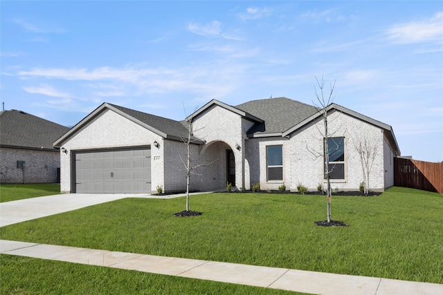 ranch-style home with a front yard, brick siding, a garage, and driveway