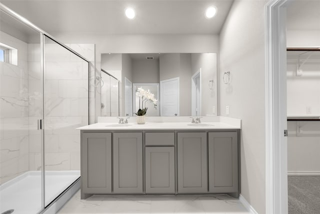 full bath featuring a sink, a marble finish shower, and a spacious closet