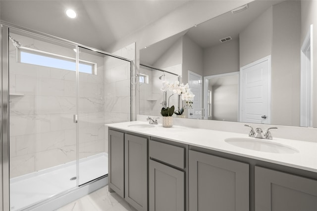 bathroom with a shower stall, double vanity, marble finish floor, and a sink