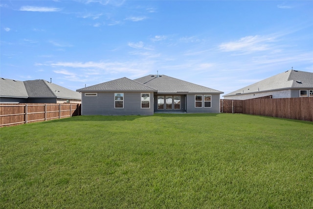 back of property featuring a lawn and a fenced backyard