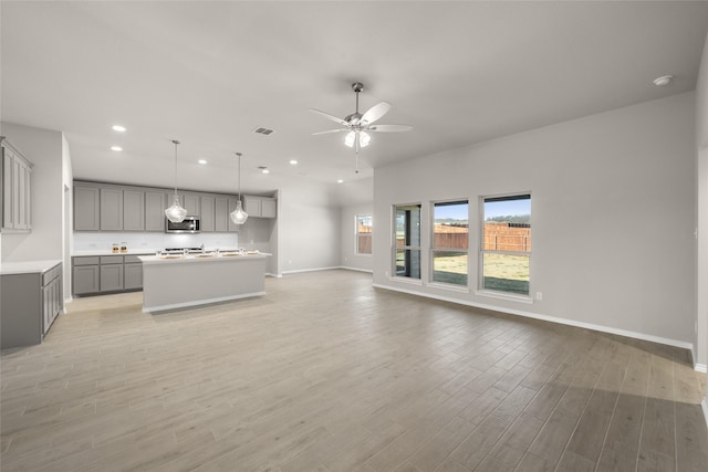 unfurnished living room featuring visible vents, baseboards, ceiling fan, light wood-type flooring, and recessed lighting