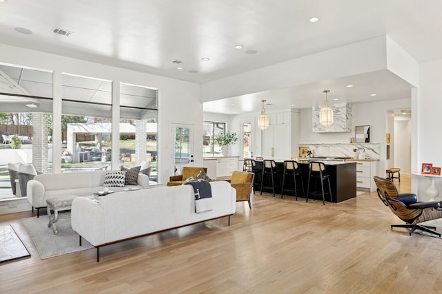 living room with recessed lighting, visible vents, and light wood-style floors