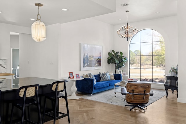 living room with visible vents, recessed lighting, parquet floors, and an inviting chandelier