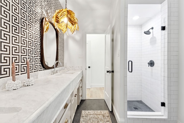 full bath featuring baseboards, vanity, a shower stall, and tile patterned flooring