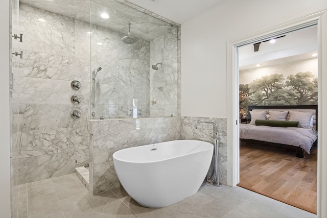 ensuite bathroom featuring ensuite bath, a freestanding tub, and a marble finish shower