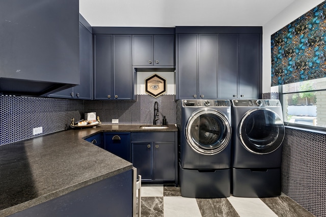 washroom featuring washing machine and clothes dryer, cabinet space, and a sink