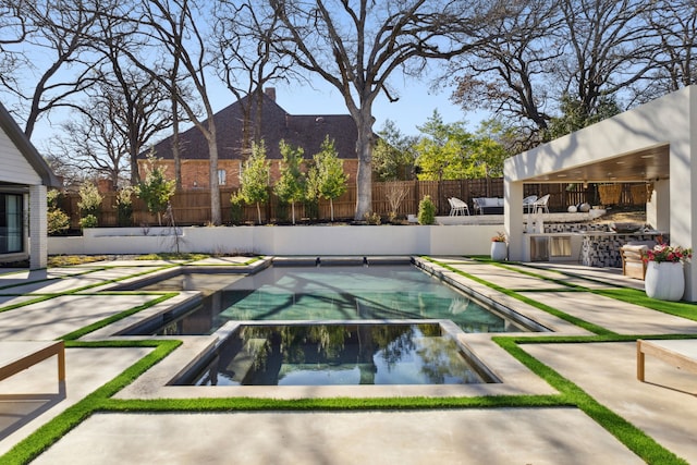 view of swimming pool featuring a patio area, fence, and a pool with connected hot tub