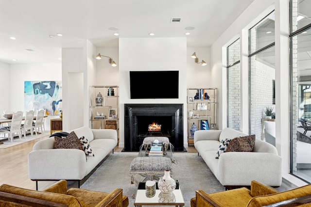 living room with visible vents, recessed lighting, a fireplace, and wood finished floors