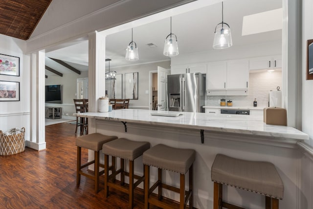 kitchen featuring dark wood finished floors, white cabinets, lofted ceiling with beams, stainless steel refrigerator with ice dispenser, and backsplash