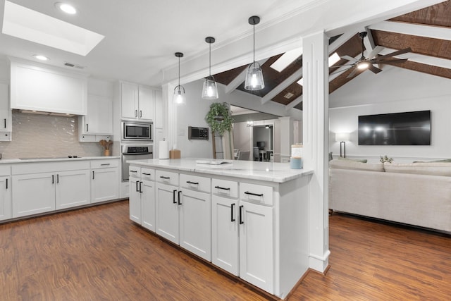 kitchen with dark wood-style flooring, stainless steel appliances, visible vents, open floor plan, and white cabinets