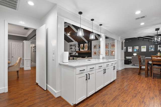 kitchen with dark wood-style floors, decorative columns, visible vents, and white cabinetry