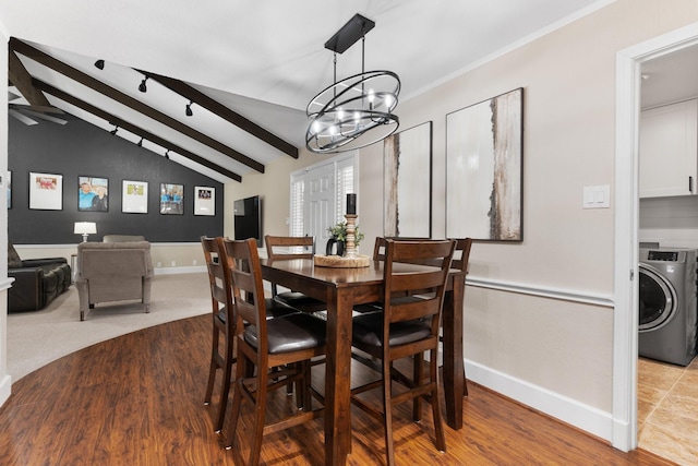 dining room with lofted ceiling with beams, a notable chandelier, washer / dryer, and baseboards