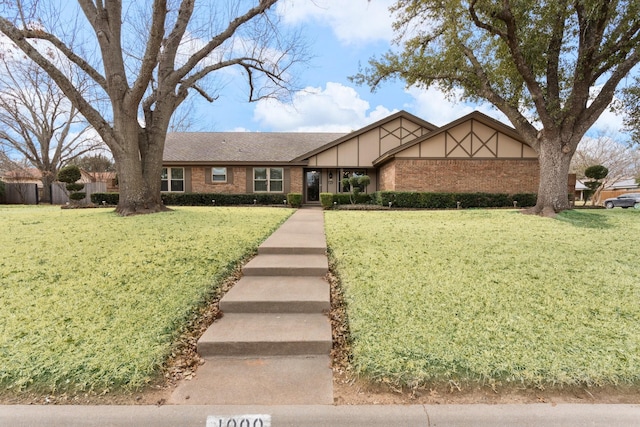 view of front of house featuring brick siding and a front yard