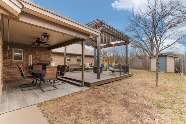 deck featuring a ceiling fan, outdoor dining space, a pergola, a fenced backyard, and an outdoor structure