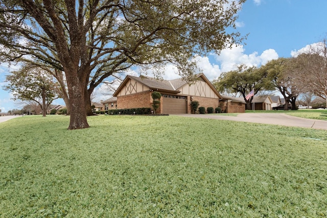 view of side of home with a yard, brick siding, driveway, and an attached garage