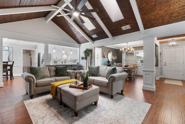 living room featuring ceiling fan with notable chandelier, beamed ceiling, visible vents, and hardwood / wood-style flooring