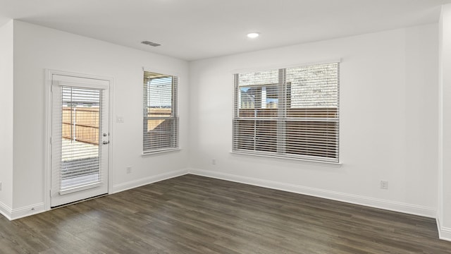 spare room featuring dark wood-style floors, baseboards, and visible vents
