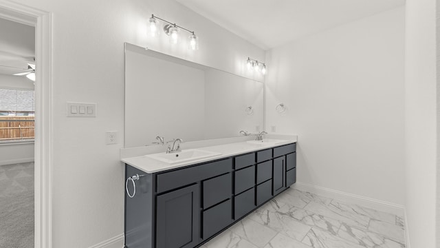 bathroom with marble finish floor, baseboards, a sink, and ceiling fan