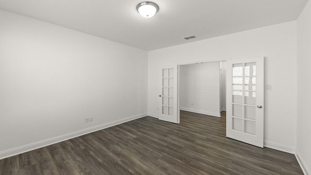 spare room with visible vents, baseboards, dark wood-style flooring, and french doors