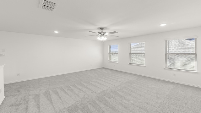 carpeted spare room featuring recessed lighting, visible vents, a ceiling fan, and baseboards
