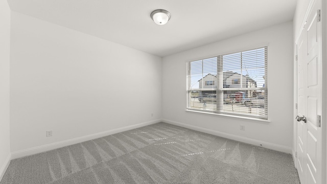 carpeted spare room with baseboards