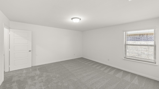 empty room featuring carpet floors and baseboards