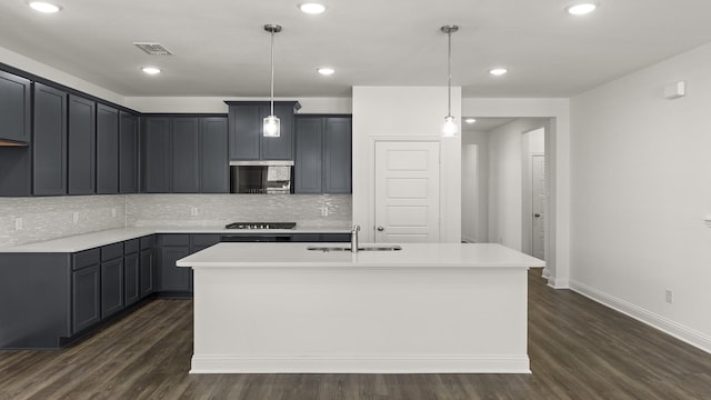 kitchen featuring dark wood finished floors, decorative backsplash, a sink, and visible vents