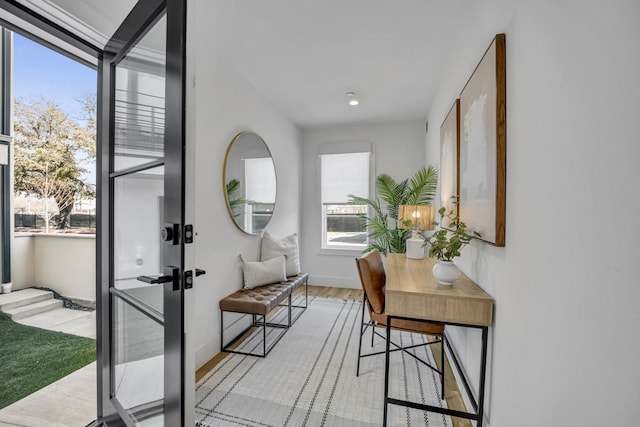 doorway to outside featuring baseboards and light wood finished floors