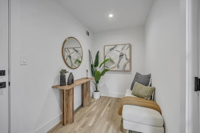 living area with light wood-style flooring, visible vents, baseboards, and recessed lighting