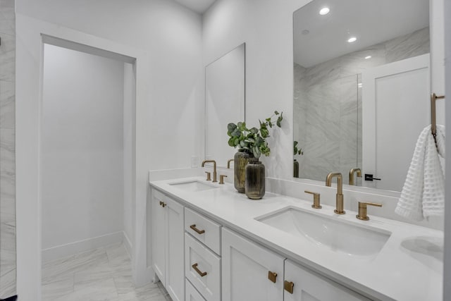 bathroom featuring marble finish floor, double vanity, a sink, and recessed lighting