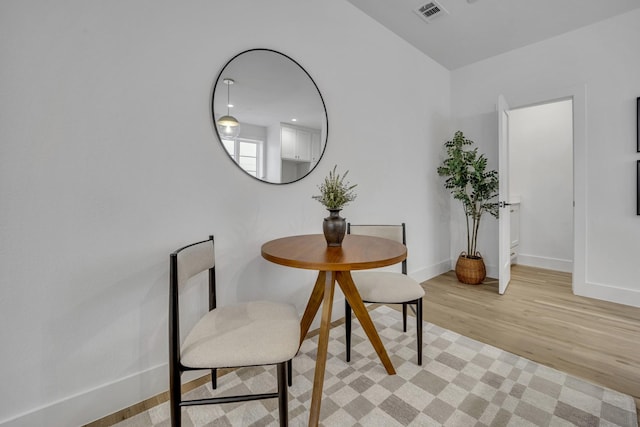 dining space with light wood-type flooring, baseboards, and visible vents