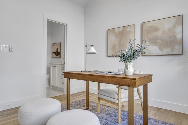 office area with light wood-style floors and baseboards