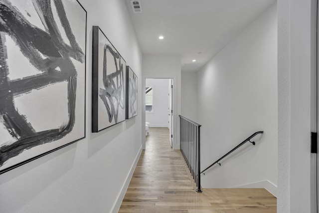 hall featuring light wood finished floors, recessed lighting, visible vents, an upstairs landing, and baseboards