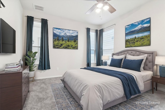 bedroom featuring baseboards, visible vents, a ceiling fan, and light colored carpet