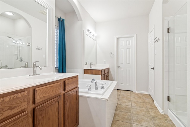 bathroom featuring a bath, tile patterned flooring, a shower stall, and a sink