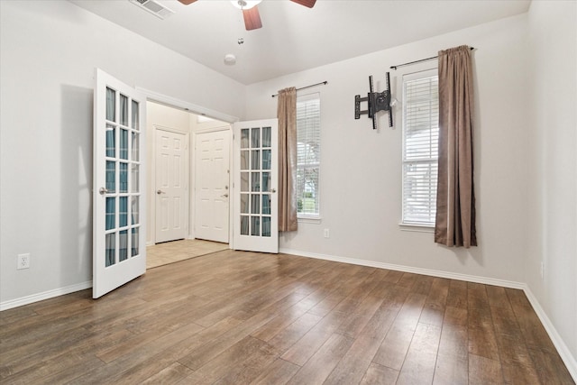 spare room with baseboards, visible vents, ceiling fan, and hardwood / wood-style floors