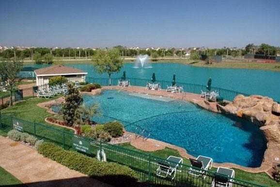 pool with a water view and fence