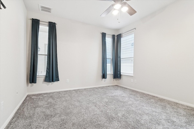 spare room featuring carpet floors, baseboards, visible vents, and a ceiling fan