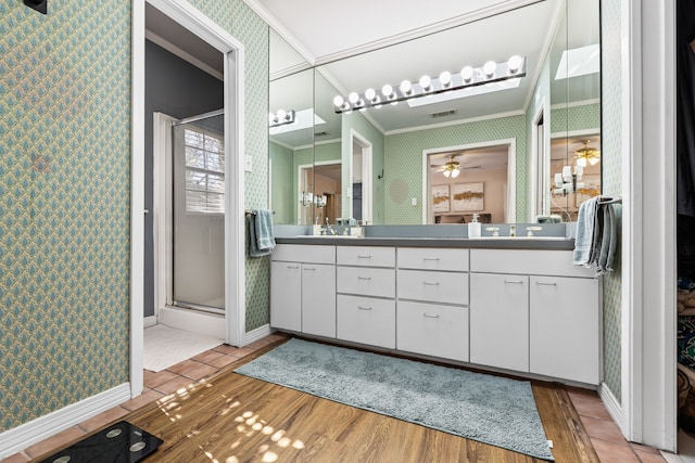 bathroom with wallpapered walls, a shower stall, visible vents, and crown molding