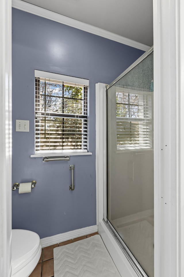 bathroom featuring baseboards, a shower stall, ornamental molding, and tile patterned flooring