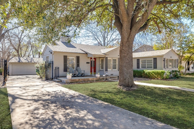 ranch-style house featuring a garage, a front lawn, roof with shingles, and an outdoor structure