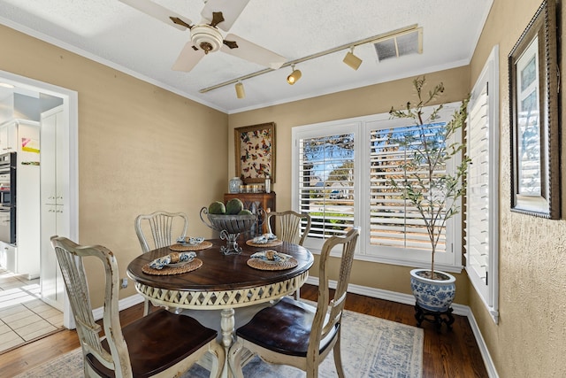 dining room with baseboards, wood finished floors, visible vents, and a ceiling fan