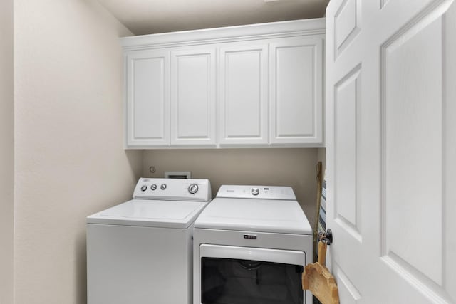 washroom with cabinet space and washer and dryer