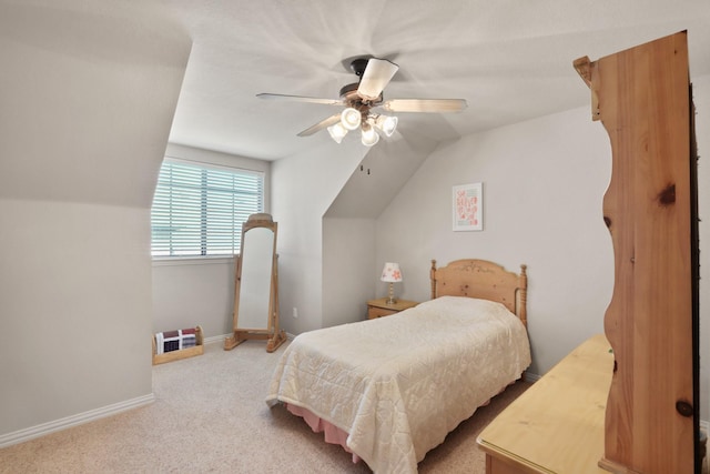 bedroom with a ceiling fan, carpet, vaulted ceiling, and baseboards