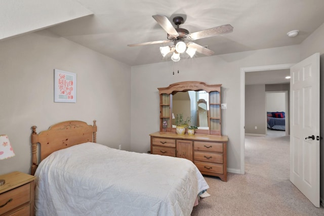 bedroom featuring baseboards, a ceiling fan, and light colored carpet