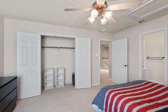 carpeted bedroom featuring a closet, visible vents, attic access, a ceiling fan, and baseboards