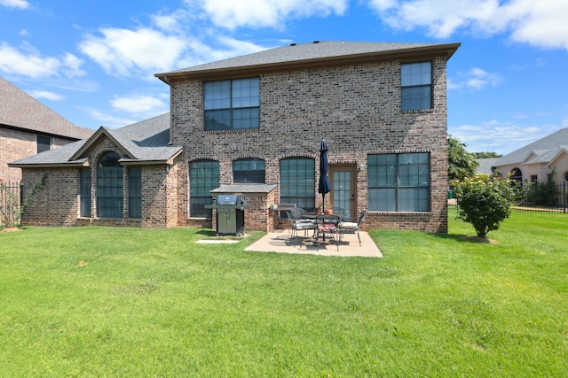 rear view of property featuring a yard, fence, a patio, and brick siding