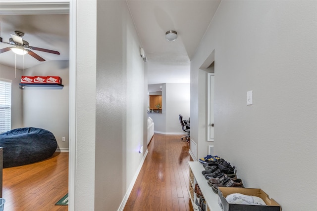 corridor with visible vents, baseboards, and hardwood / wood-style floors