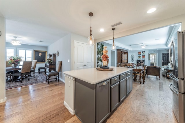 kitchen featuring visible vents, open floor plan, freestanding refrigerator, light wood finished floors, and ceiling fan